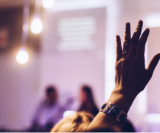 An image showing a participant rising hand in an event hosted at One&Co co-working office.