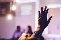 An image showing a participant rising hand in an event hosted at One&Co co-working office.